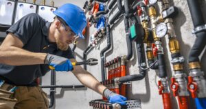 The technician checking the heating system in the boiler room.